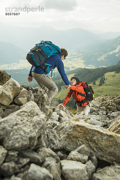 Österreich  Tirol  Tannheimer Tal  junges Paar beim Felsenwandern