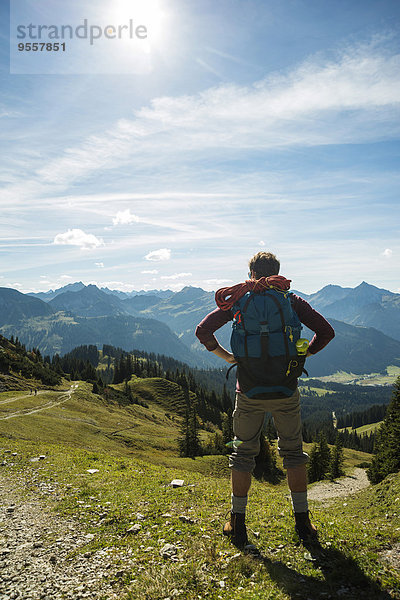 Österreich  Tirol  Tannheimer Tal  junger Mann in den Bergen mit Blick auf die Berge
