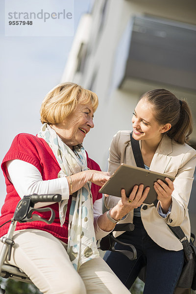 Enkelin und Großmutter mit digitalem Tablett
