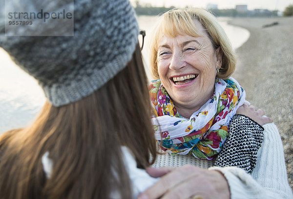 Porträt der lächelnden blonden Seniorin von Angesicht zu Angesicht zu ihrer Enkelin