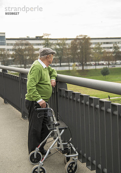 Senior mit Rollator auf der Brücke