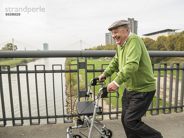 Verspielter Senior mit Rollator auf der Brücke