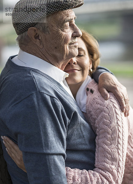 Tochter umarmt älteren Mann im Freien