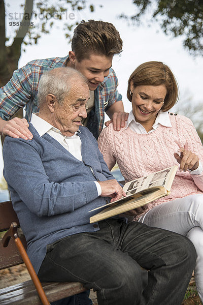 Senior Mann mit Enkel und Tochter beim Betrachten des Fotoalbums