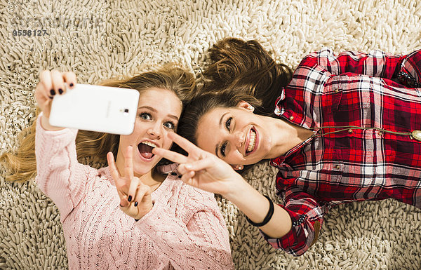 Zwei Freundinnen nehmen einen Selfie mit Smartphone mit nach Hause
