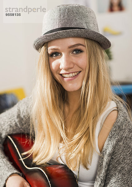 Porträt der lächelnden blonden Teenagerin mit Hut
