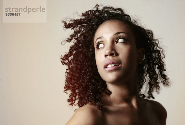 Porträt einer jungen Frau mit Afro aufblickend