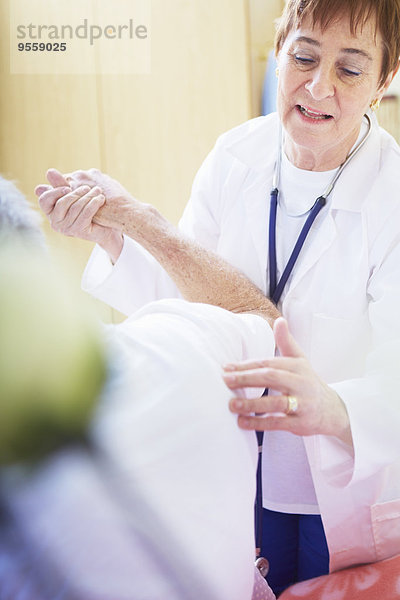 Arzt untersucht älteren Mann im Krankenhausbett