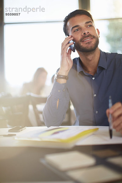 Portrait eines Geschäftsmannes beim Telefonieren mit dem Smartphone im Restaurant