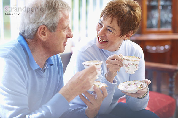 Fröhliches Seniorenpaar trinkt Kaffee zu Hause