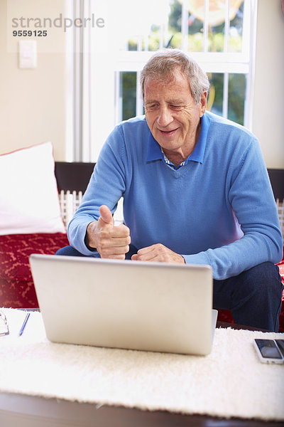 Senior Mann mit Laptop zu Hause