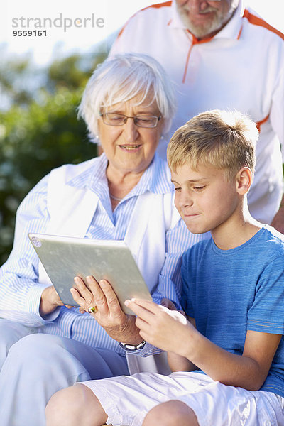 Enkel und Großeltern mit digitalem Tablett