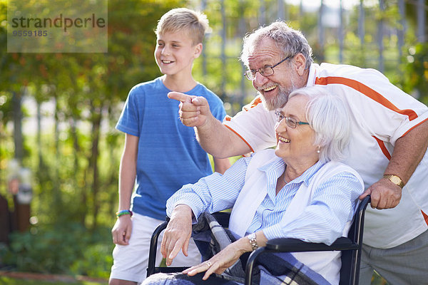 Großvater und Enkel mit Großmutter im Rollstuhl