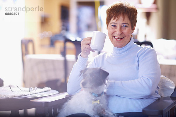 Glückliche Seniorin mit Hund zu Hause