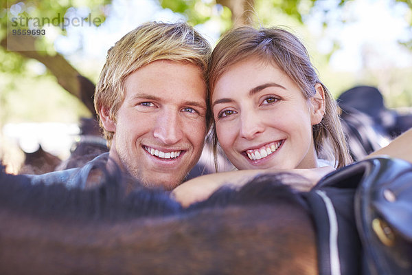 Porträt eines lächelnden jungen Paares mit Pferd