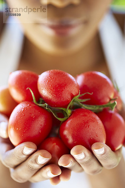 Frauenhände mit Tomaten in der Hand