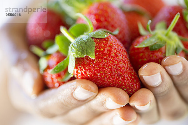 Frauenhände mit Erdbeeren in der Hand