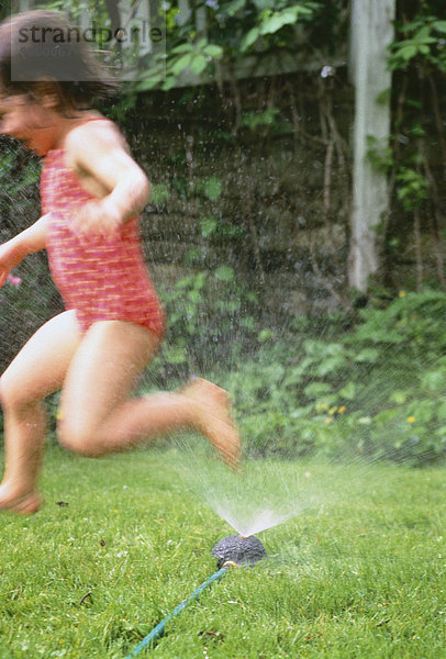 Girl in Swimwear  Playing in Sprinkler