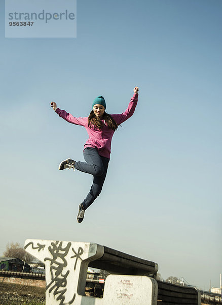 Außenaufnahme Jugendlicher über springen Sitzbank Bank Mädchen Industriegebiet freie Natur
