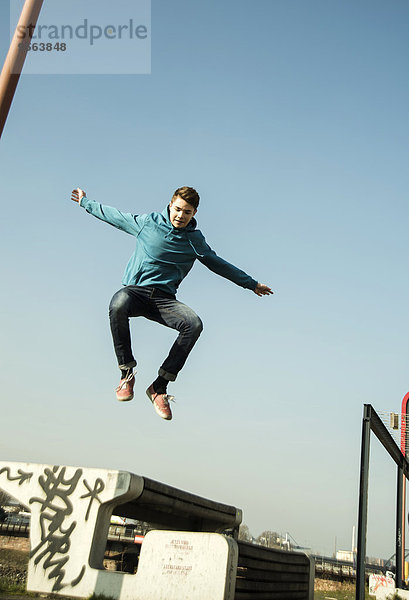 Außenaufnahme Jugendlicher Junge - Person über springen Sitzbank Bank freie Natur