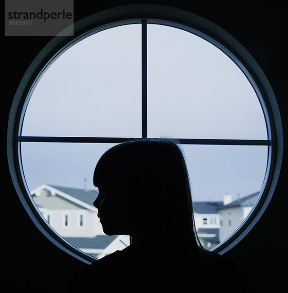 Ein Kind im Profil in einem runden Fenster