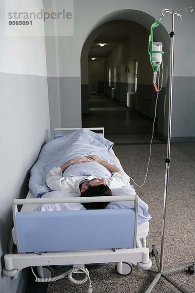 Ein Mann  der in einem Krankenhausbett liegt.