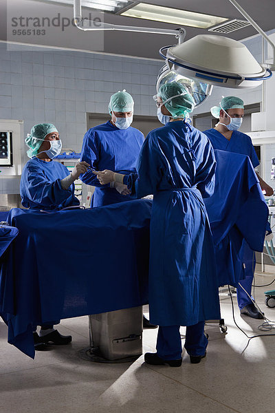 Ein OP-Team  das einen Patienten in einem Operationssaal operiert.