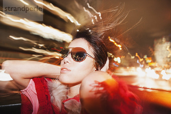 Glamouröse Frau mit Sonnenbrille genießt Autofahrt