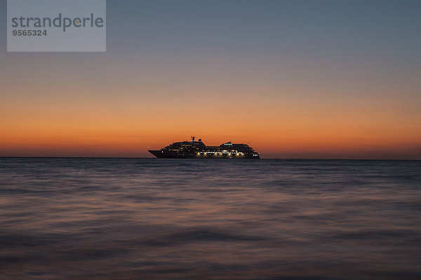 Silhouette-Kreuzfahrtschiff auf See bei Sonnenuntergang