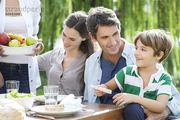 Familie isst zusammen im Freien  Vater hält Sohn auf Schoß