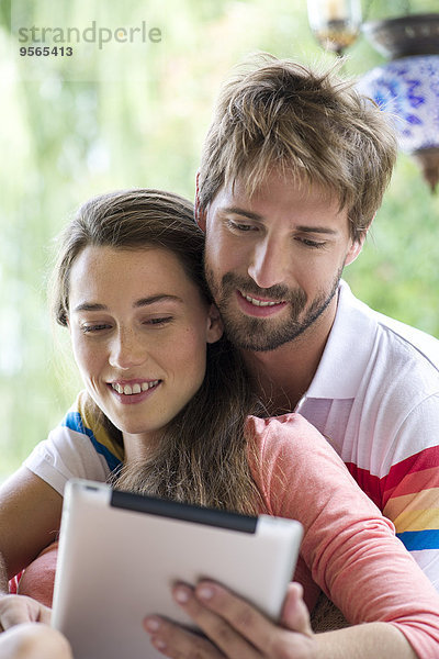 Junges Paar mit digitalem Tablett zusammen im Freien