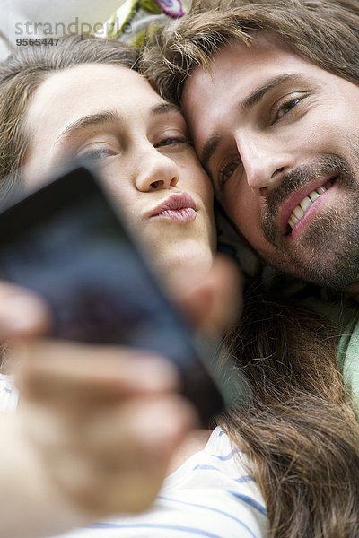 Junges Pärchen nimmt Selfie mit Smartphone