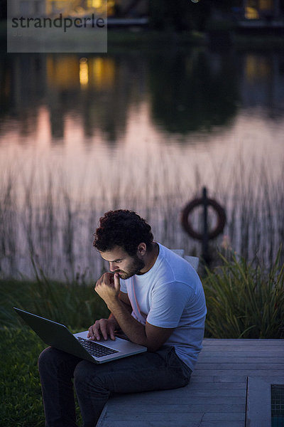 Mann mit Laptop auf dem Seedeck