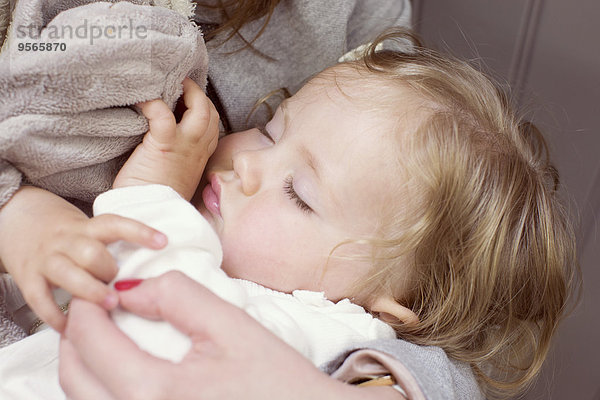 Babymädchen schläft in den Armen der Mutter  abgeschnitten