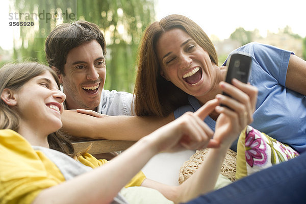 Junge Frau teilt Fotos auf dem Smartphone mit Freunden