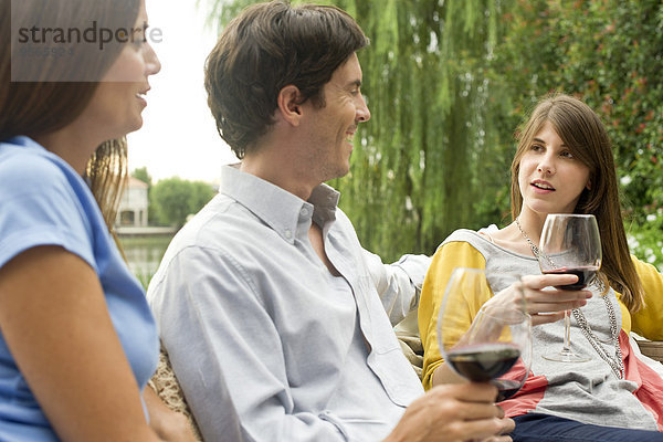 Freunde  die sich bei einem Glas Wein im Freien entspannen.