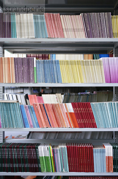 Viele farbenfrohe Bücher im Bücherregal angeordnet