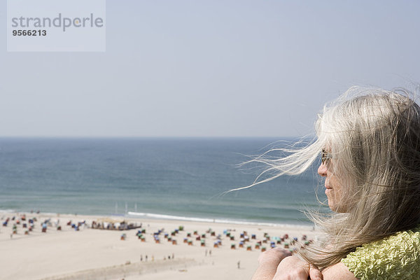 Eine erwachsene Frau mit Blick über den Strand