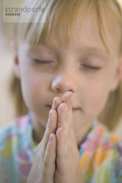 Mädchen beten mit geschlossenen Augen