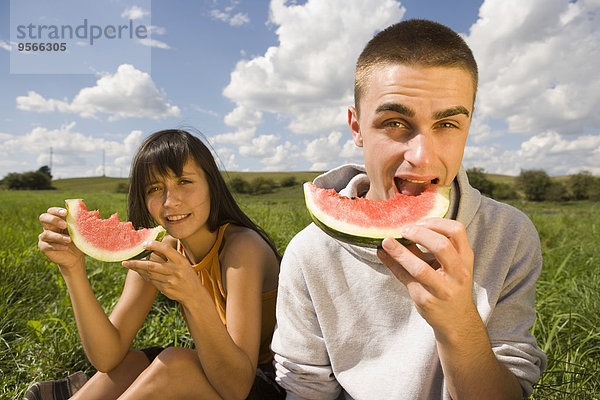 Junges Paar isst Wassermelone im Feld