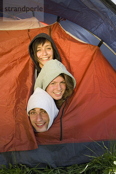 Drei Freunde drängten sich im Zelt.