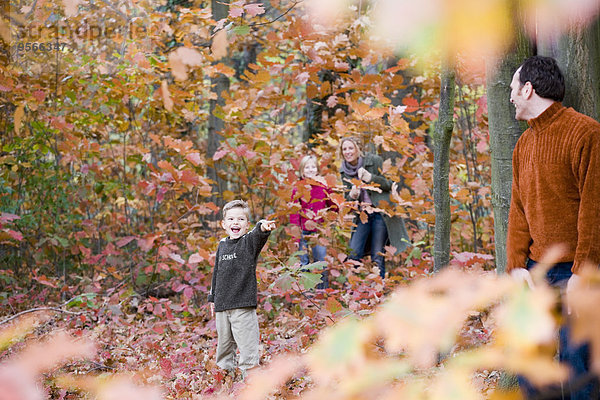 Vierköpfige Familie beim Verstecken im Wald