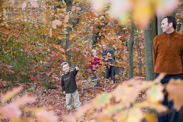 Vierköpfige Familie beim Verstecken im Wald