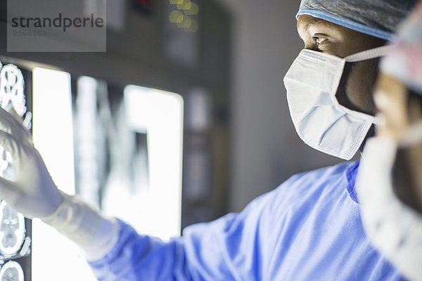 Mittlerer Erwachsener Mann  der das MRT des Patienten untersucht.