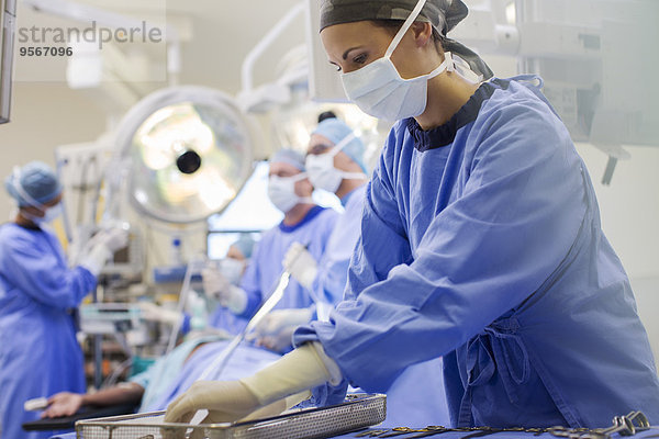 Krankenschwester mit Peelings zur Vorbereitung medizinischer Instrumente im Operationssaal