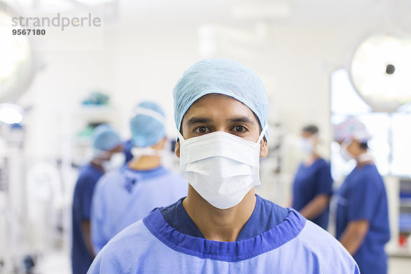 Portrait des Chirurgen mit OP-Kappe  Maske und Kittel im Operationssaal