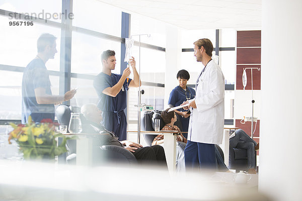 Ärzte  die sich um Patienten kümmern  die sich in der Ambulanz behandeln lassen.