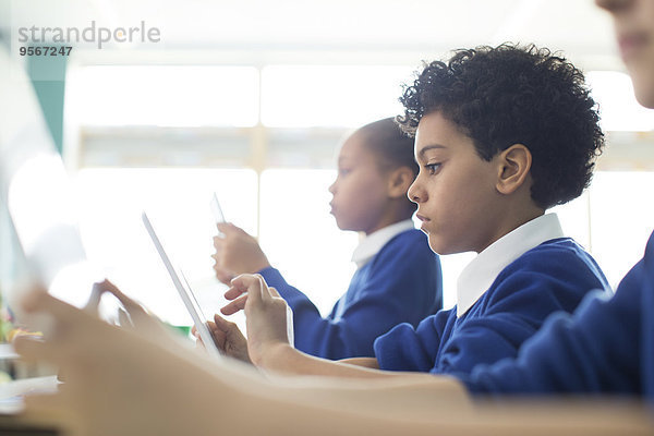 Schülerinnen und Schüler sitzen im Klassenzimmer mit Tablet-PC's