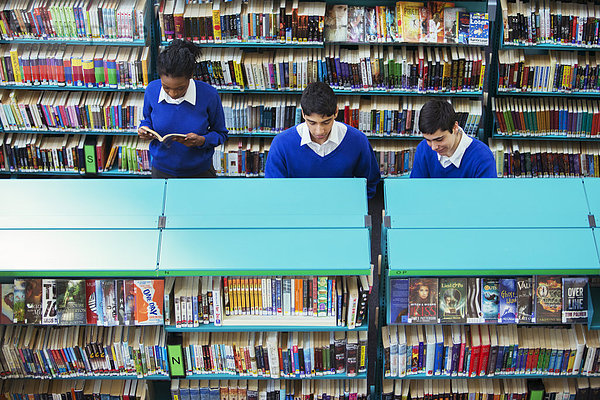 Schüler lernen im Klassenzimmer mit Buch und Tablet PC