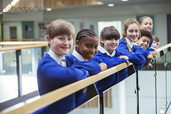 Porträt von Grundschulkindern in blauen Schuluniformen im Schulflur stehend